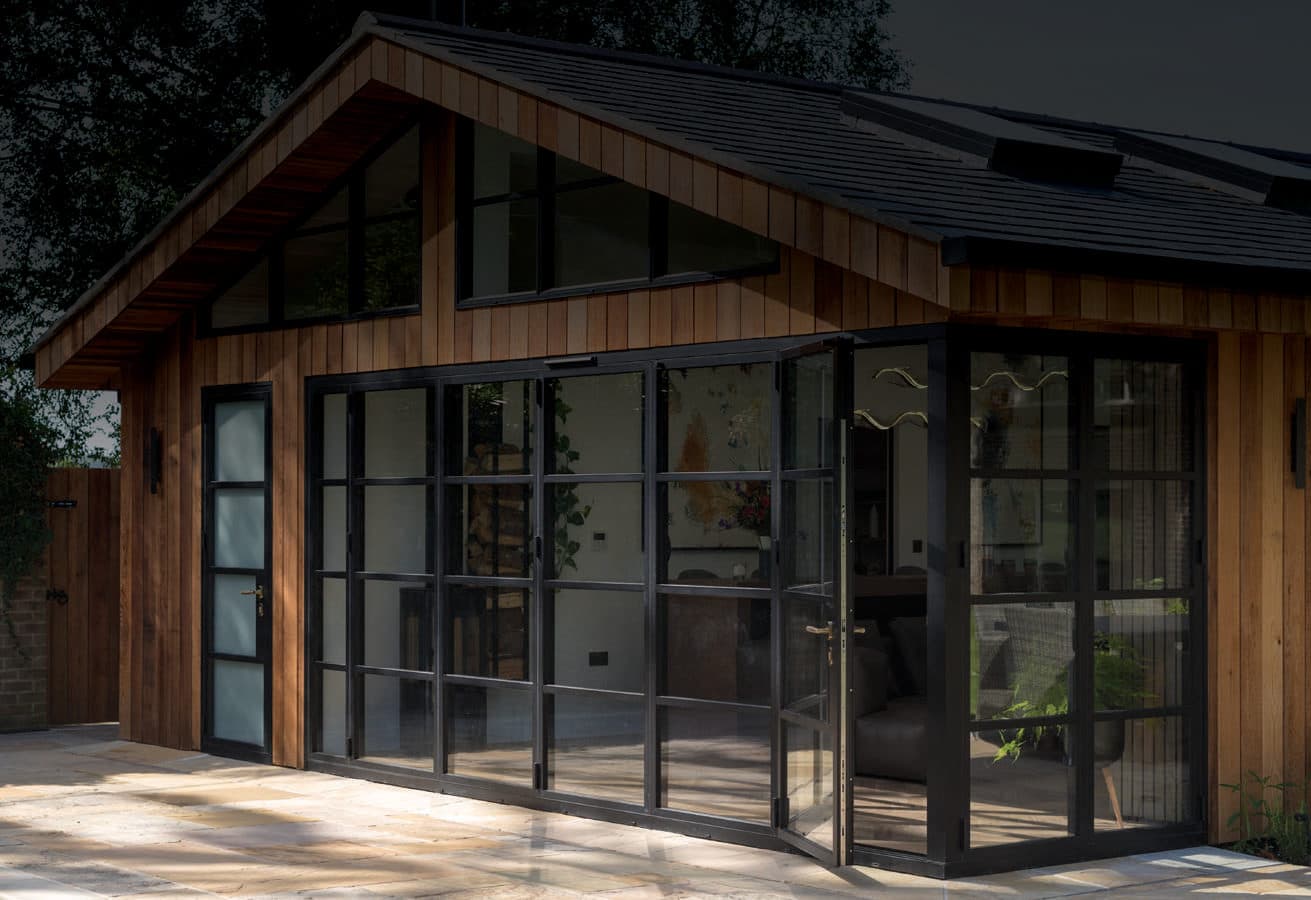 Origin aluminium heritage steel-look bifold doors on a timber-clad garden room