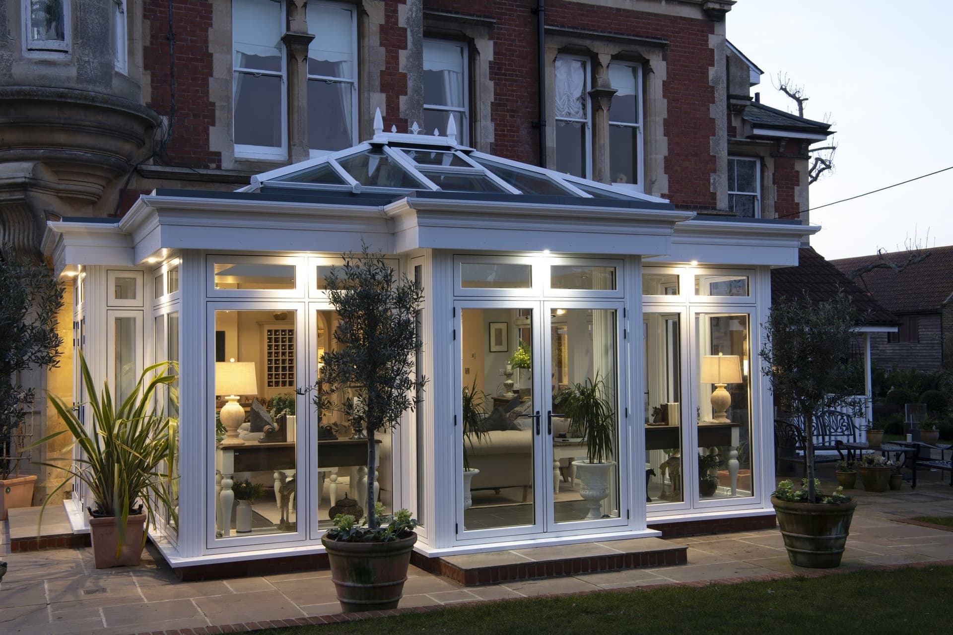 Orangery extension at dusk with warm interior lighting and bifold doors