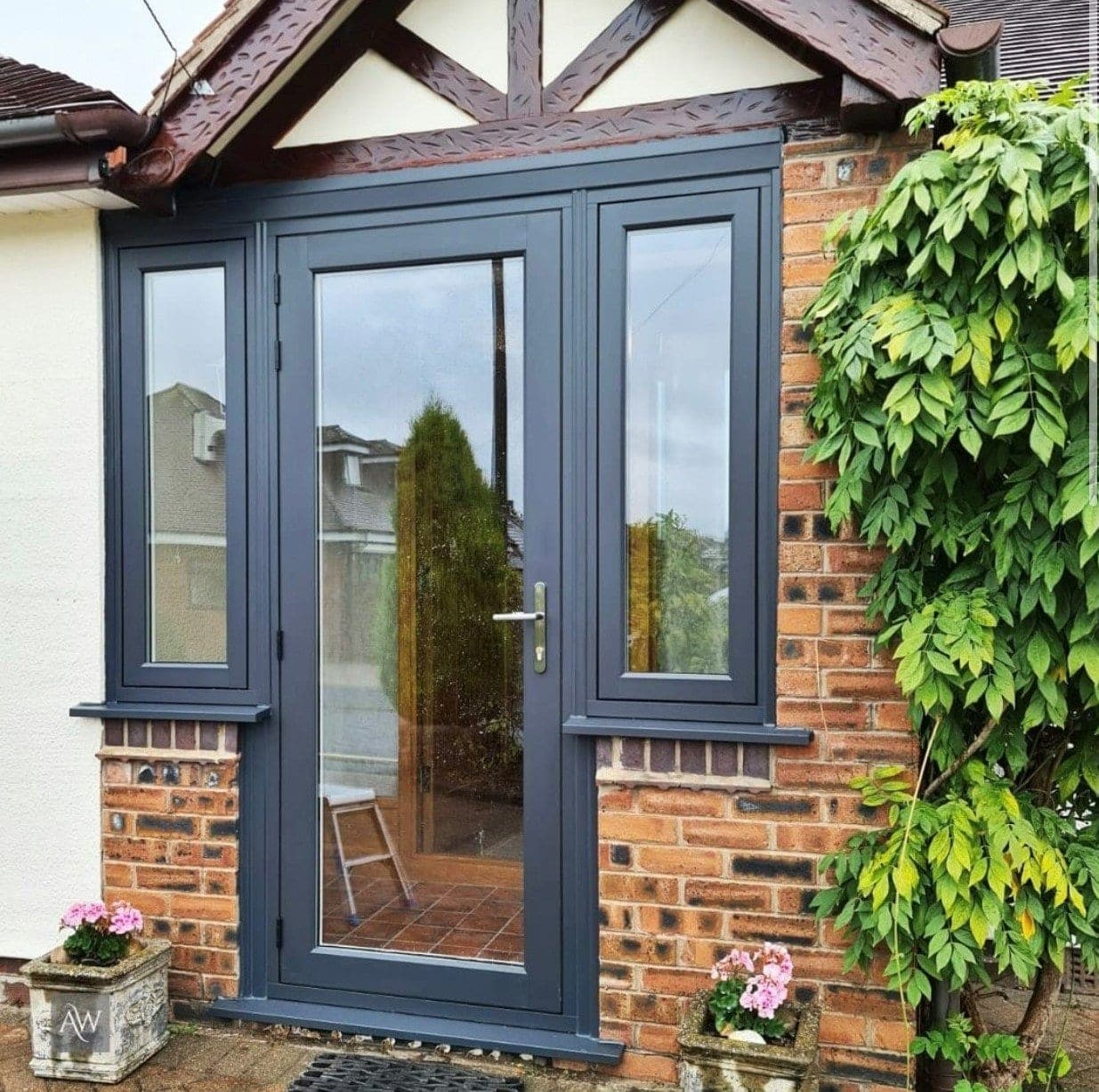 Residence R7 entrance door in Eclectic Grey with matching sidelights on a porch