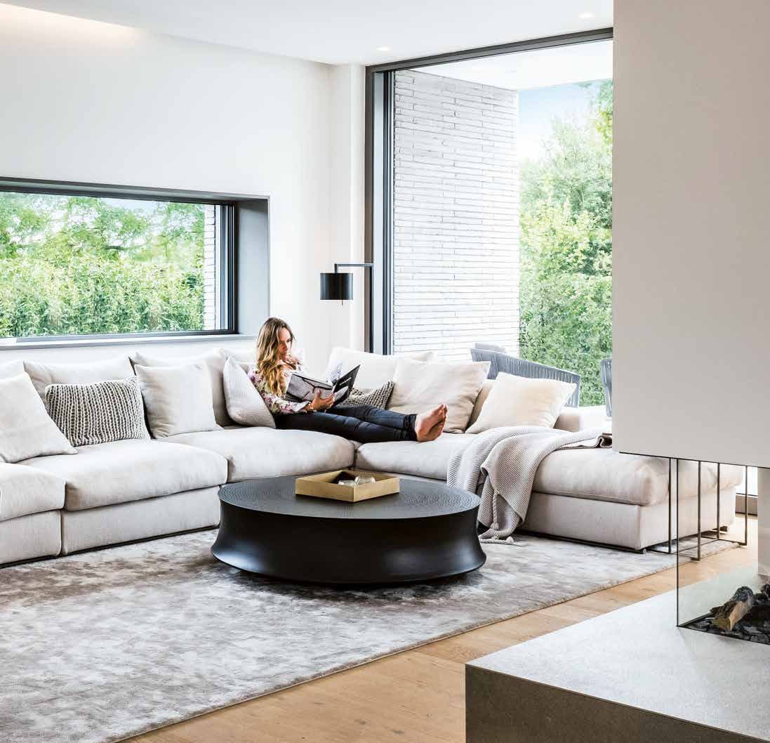 Schüco aluminium sliding doors framing a garden view from a contemporary living room