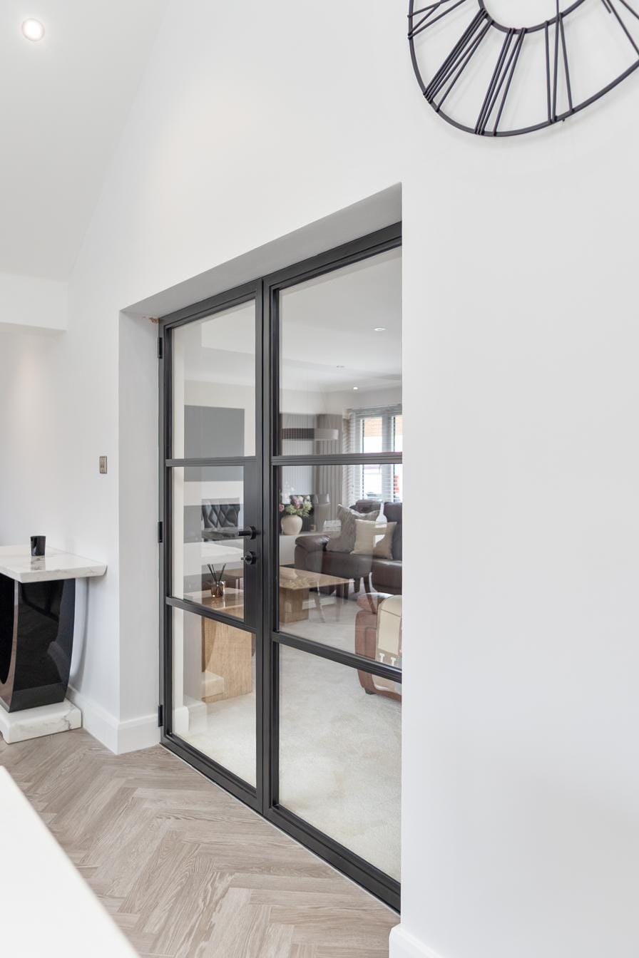 Real Custom Choice install — Origin Soho-style aluminium sliding doors with black slim frames and steel-look horizontal bars on a herringbone-floor interior
