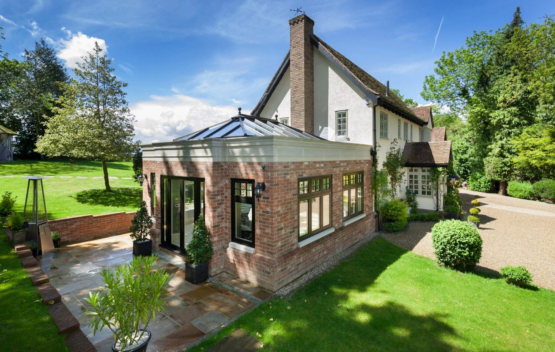 Brick orangery extension with a glazed roof lantern on a period country house