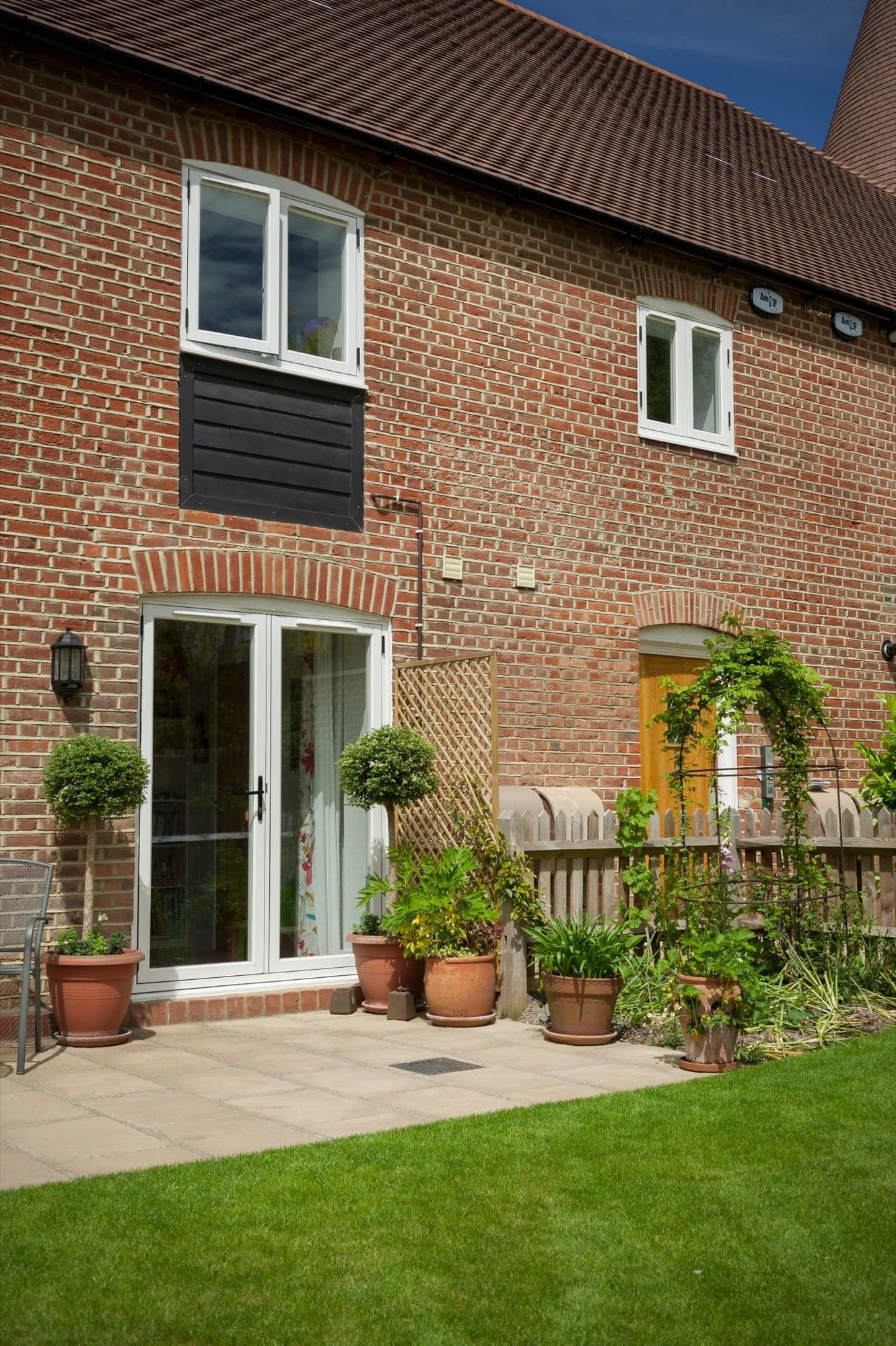 White uPVC back door and casement windows on a red brick home