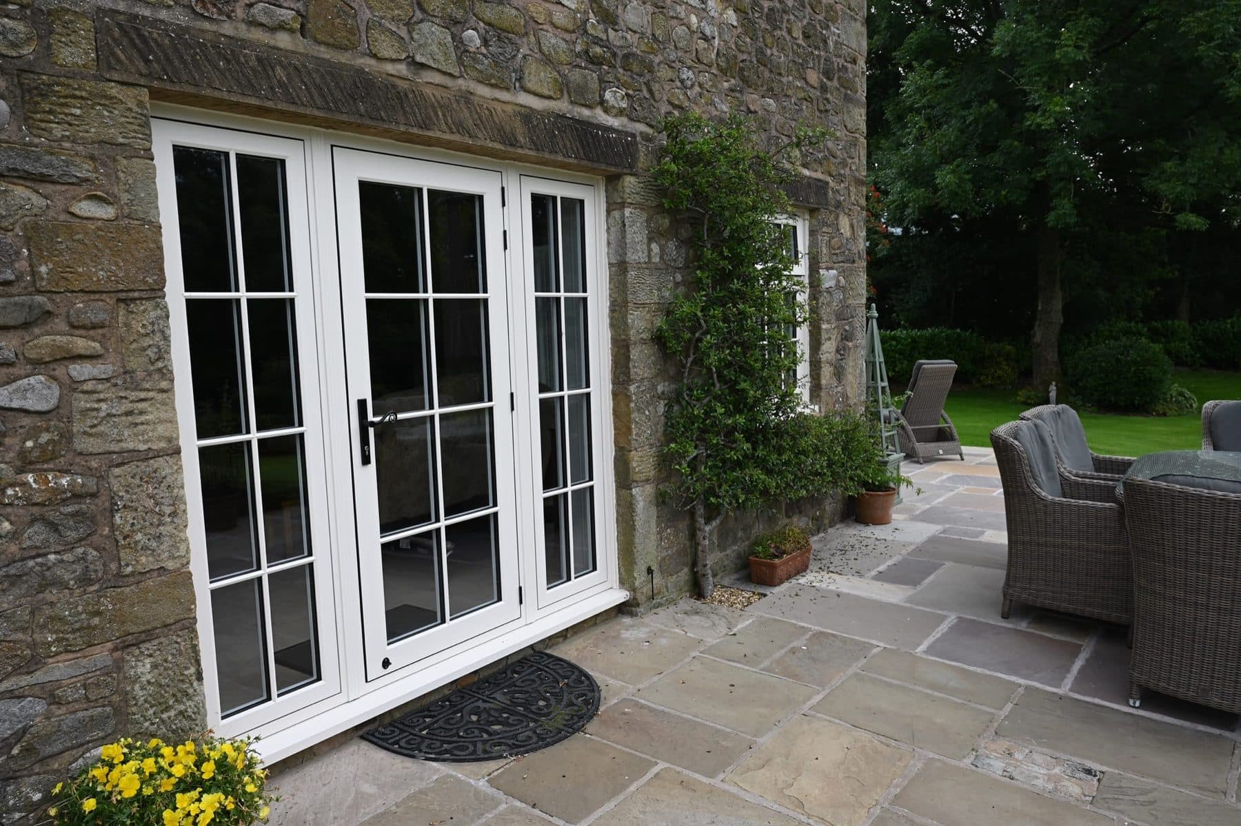 Cream French doors on a traditional stone cottage — Schüco-quality engineering