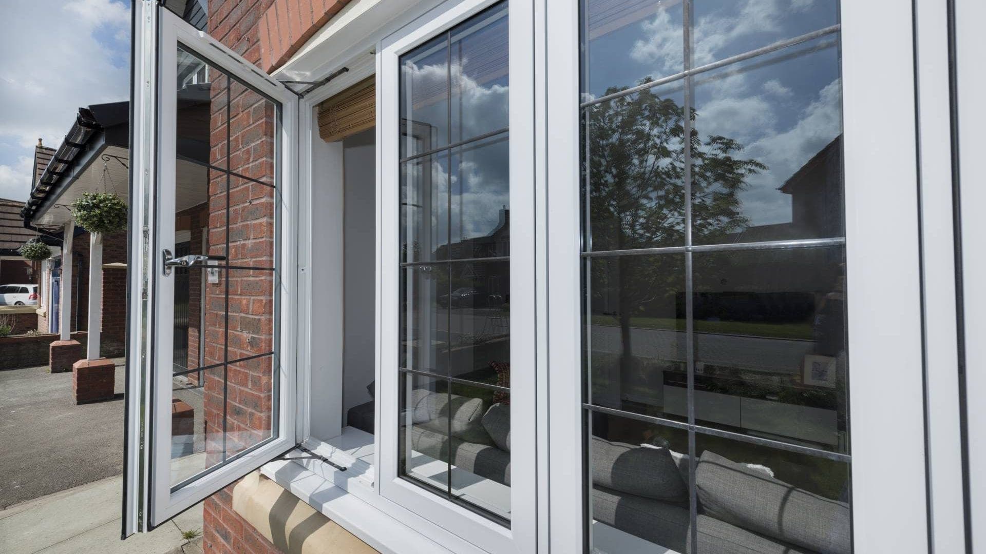 White uPVC casement windows opened outward on the corner of a conservatory, A-rated double glazing